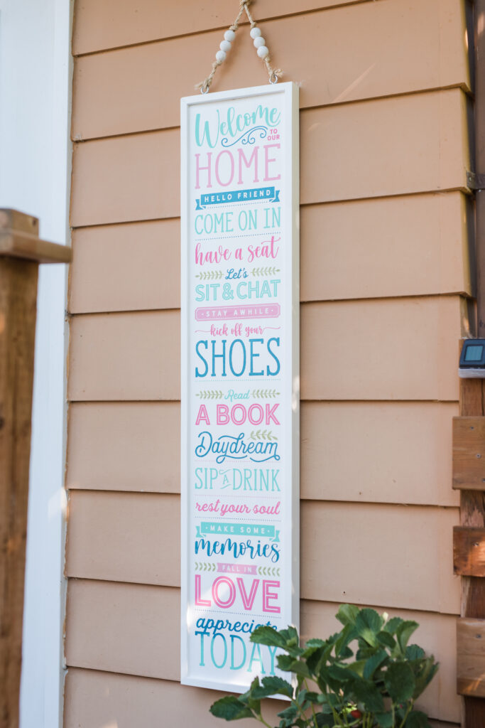 Pink and blue back deck welcome sign