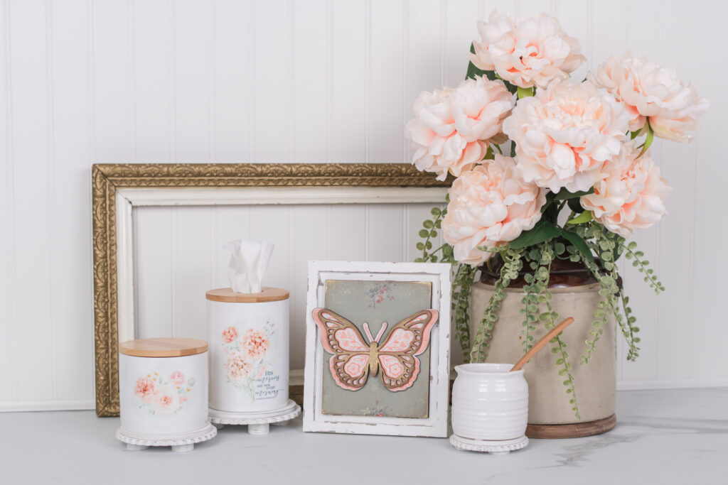 Styled home decor vignette of Chalk Couture's floral butterfly transfer on an IOD lattice, rose paint inlay background.