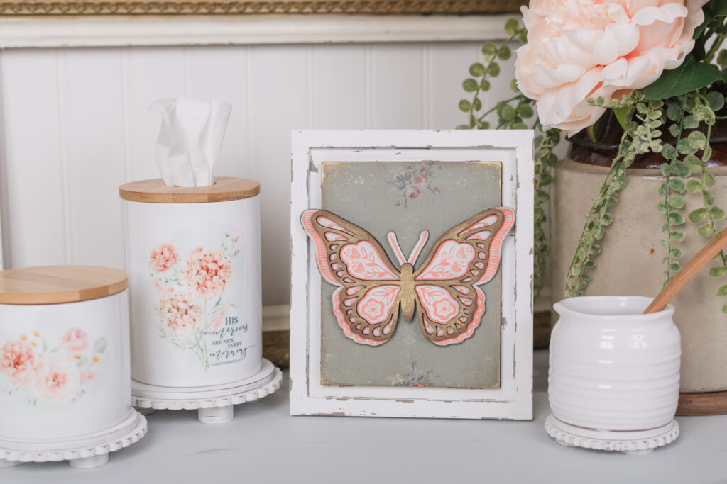 Artistic photo of a seasonal interchangeable frame featuring a high-end chalk couture butterfly design and vibrant IOD paint inlay on wood.
