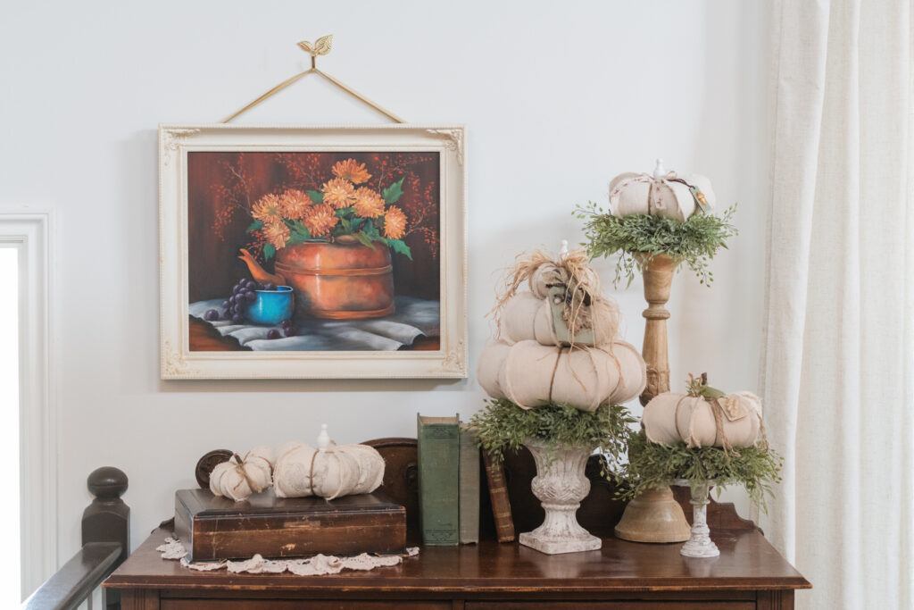 DIY drop cloth pumpkin topiaries in the living room on candle sticks and risers decorated for fall 