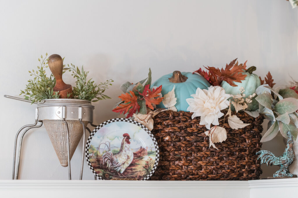  thrifted sieve, mixed with vintage rooster plates in a basket, full of pumpkins and fall florals 