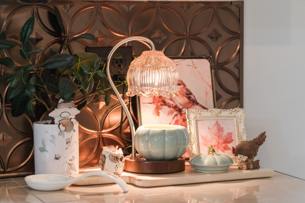  Candle warmer for a pumpkin candle, styled on a tray with some printable art, and one of my magnolia canisters used as a planter, mixed with some vintage vines