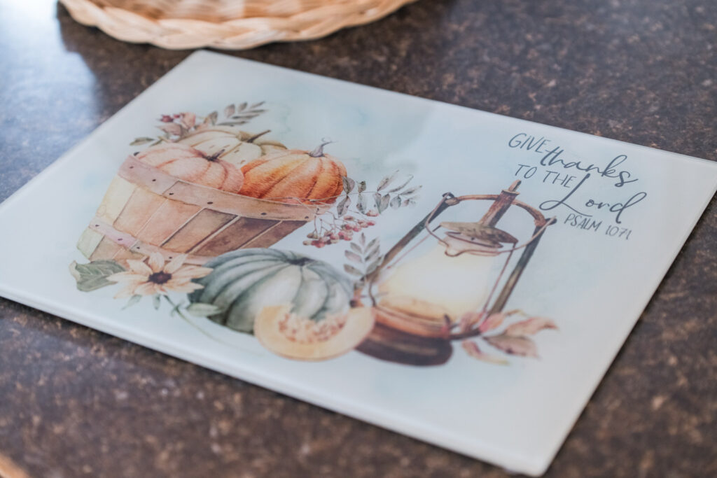 cozy autumn glass cutting board used as a prep surface in kitchen