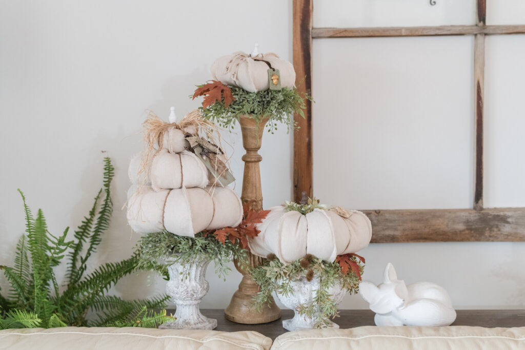 DIY drop cloth pumpkins on candle sticks in the living room on the sofa table 