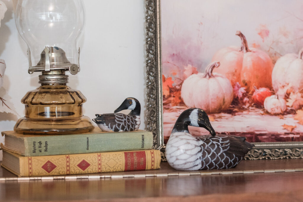 Wooden hand-painted Canada geese styled on a piano for fall 
