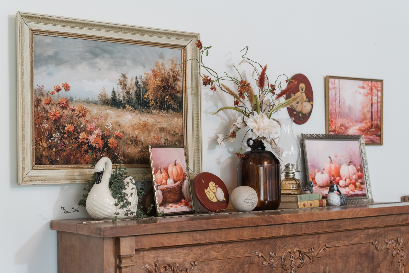Fall gallery wall, layered with printed art, handmade pieces, vintage books, and fall florals over top of a vintage piano