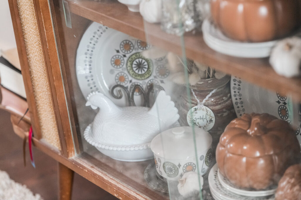 A peek inside a vintage, china cabinet decorated for fall