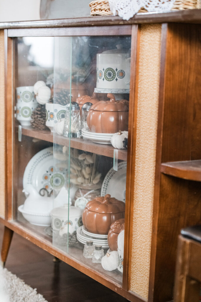 Vintage china cabinet passed down with new and old dishes decorated for fall 