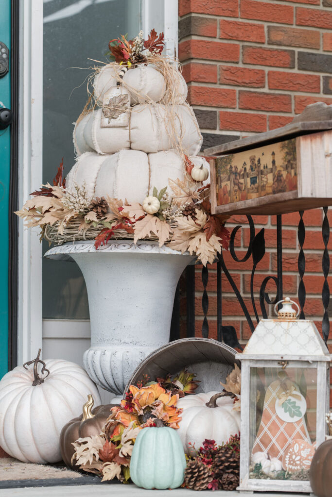 Fall front step styled with DIY dropcloth, topiary pumpkins in cast-iron urns, surrounded by hand, painted pumpkins and decor 
