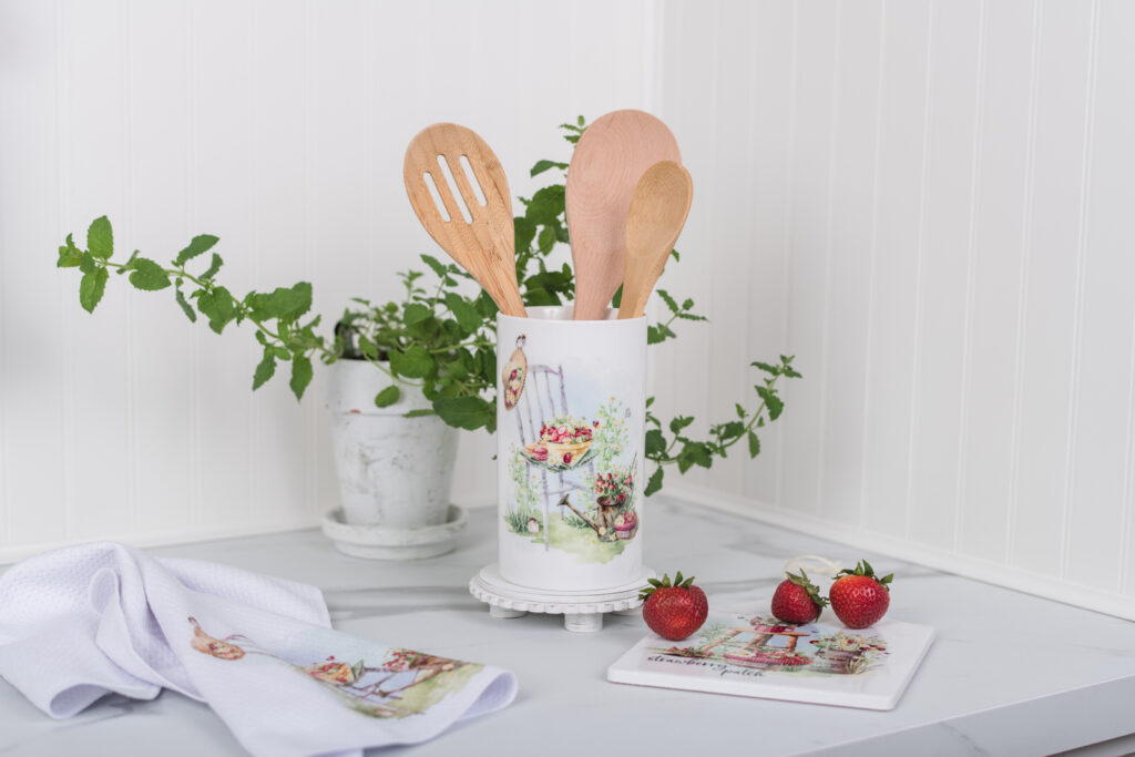 Strawberry large canister used as a utensil holder, styled with a tea towel and trivet for a charming summer feel