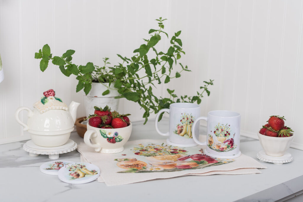 Watercolour strawberry coffee mugs on placemats for a charming breakfast table.