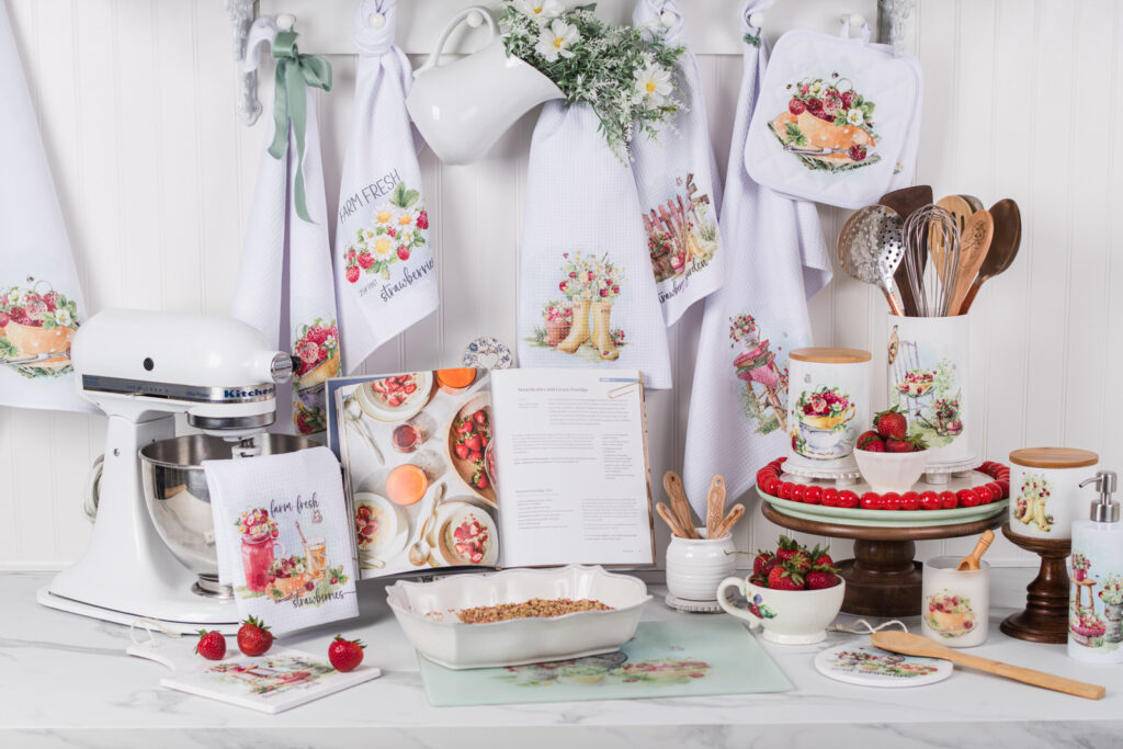 Strawberry Patch Collection styled in a kitchen with watercolor strawberries, canisters, aprons, and mugs.