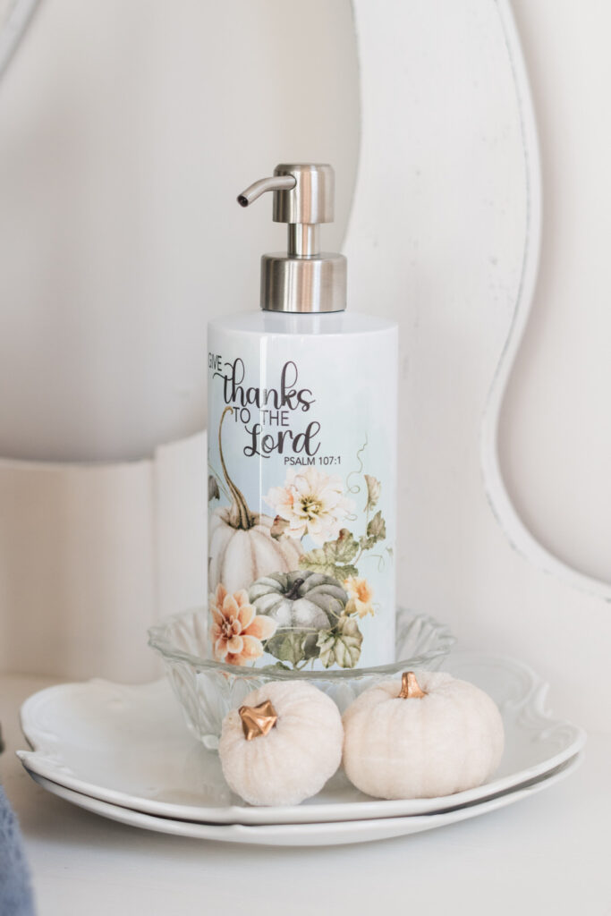 Give thanks to the lord soap dispenser, place on stacked plates with pumpkins, on a vintage vanity 