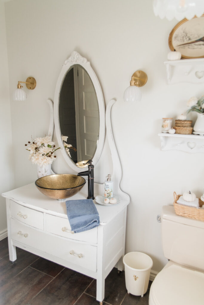 Farmhouse bathroom lighting with brass and glass fixtures over a vintage vanity