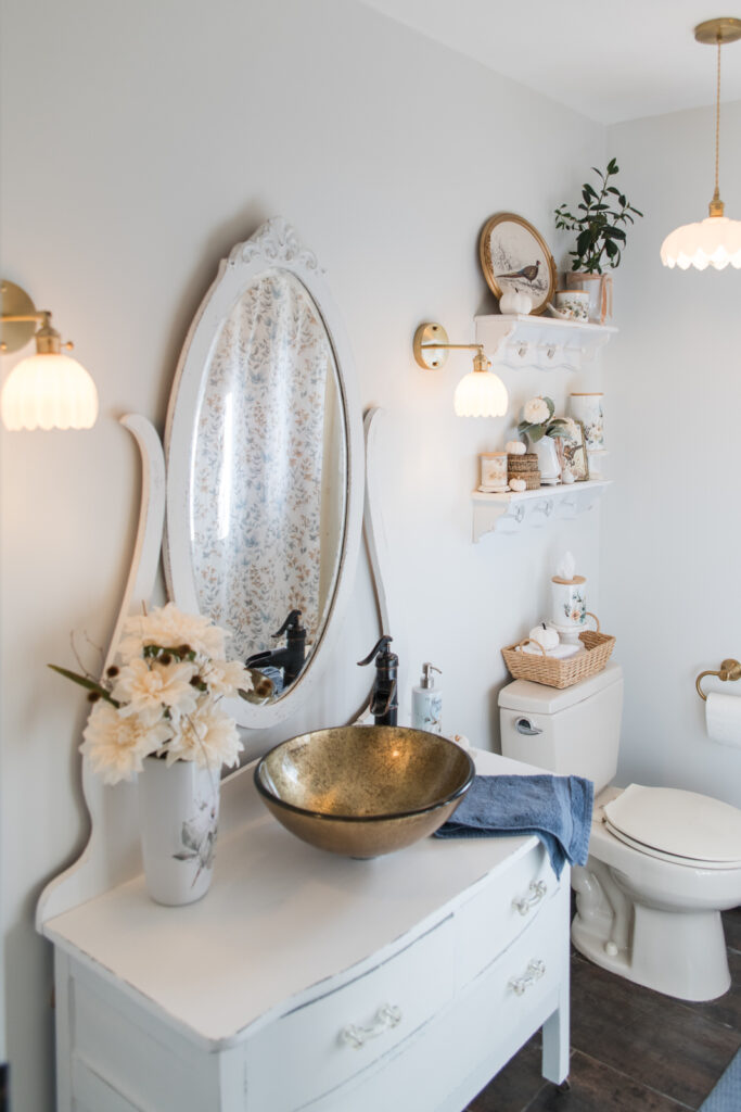 cottage style bathroom lighting with brass and glass fixtures with a vintage vanity 