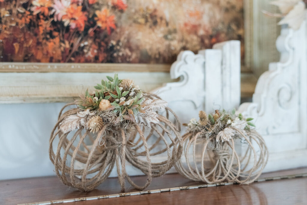 DIY jute pumpkins styled on top of a piano in front of handmade corbels 