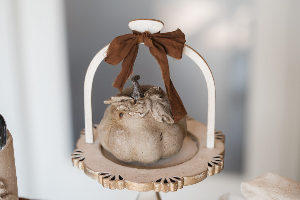 Close-up of painted gourd with IOD mould leaf painted in earthy tones on a wooden cloche