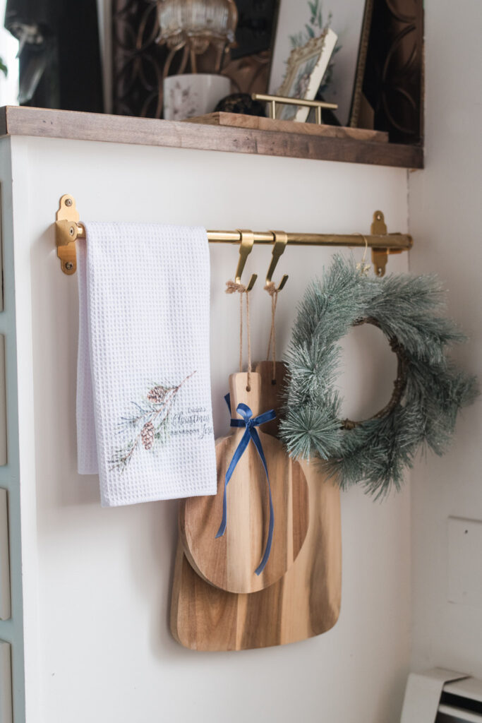 noel tea towel styles at the end of a counter with a wreath and cutting boards