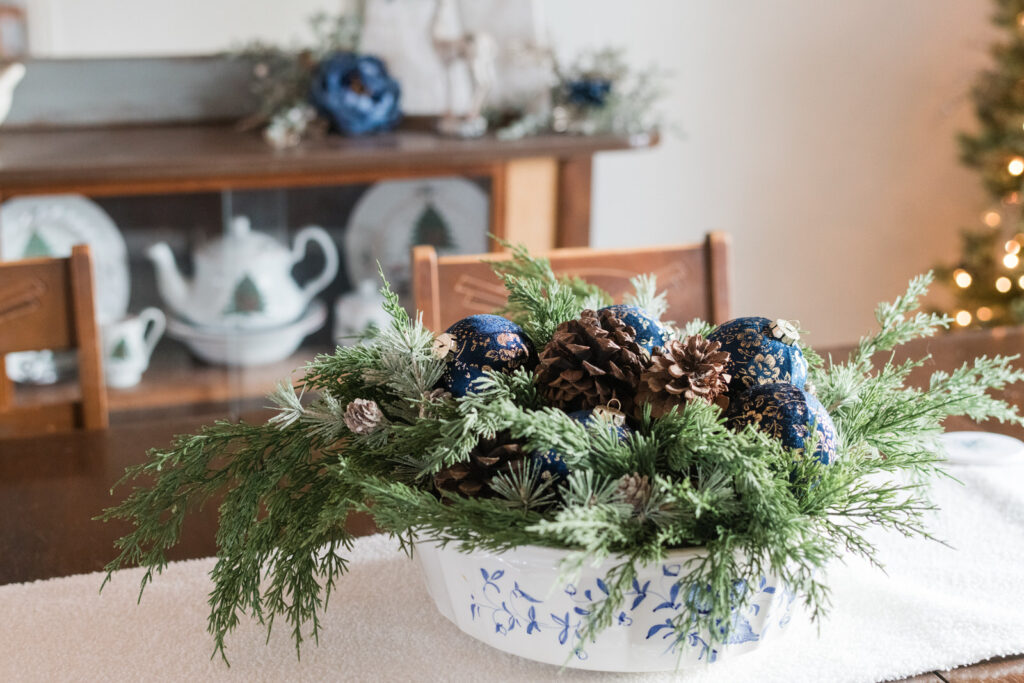 Simple Christmas table decor featuring a blue Delft-style bowl with natural greenery