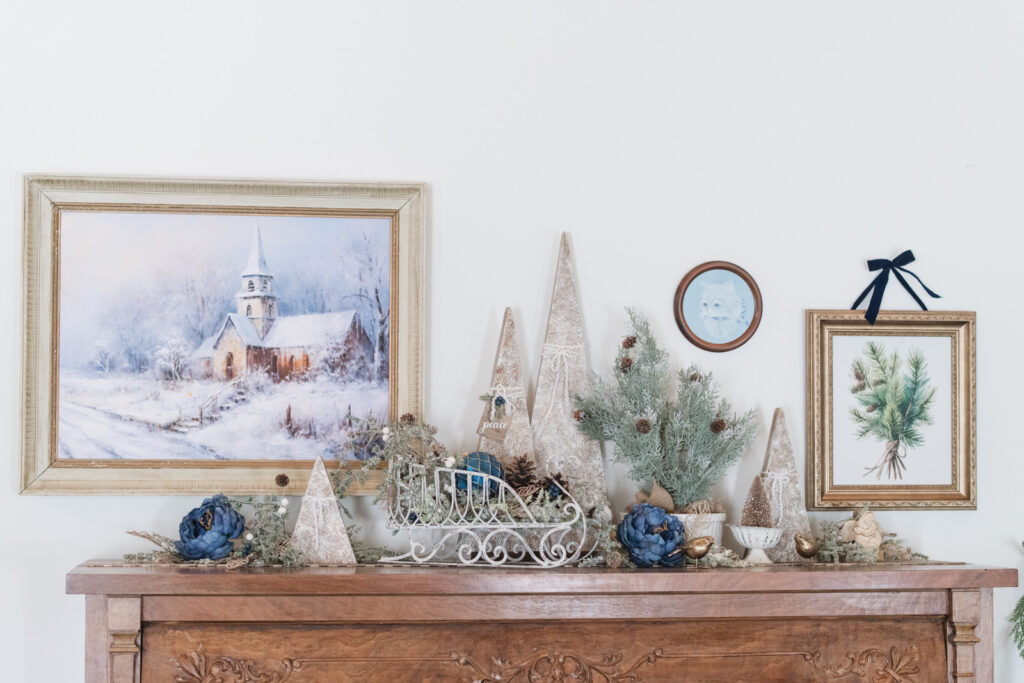 Piano decorated for Christmas with layered trees, garland, and artwork