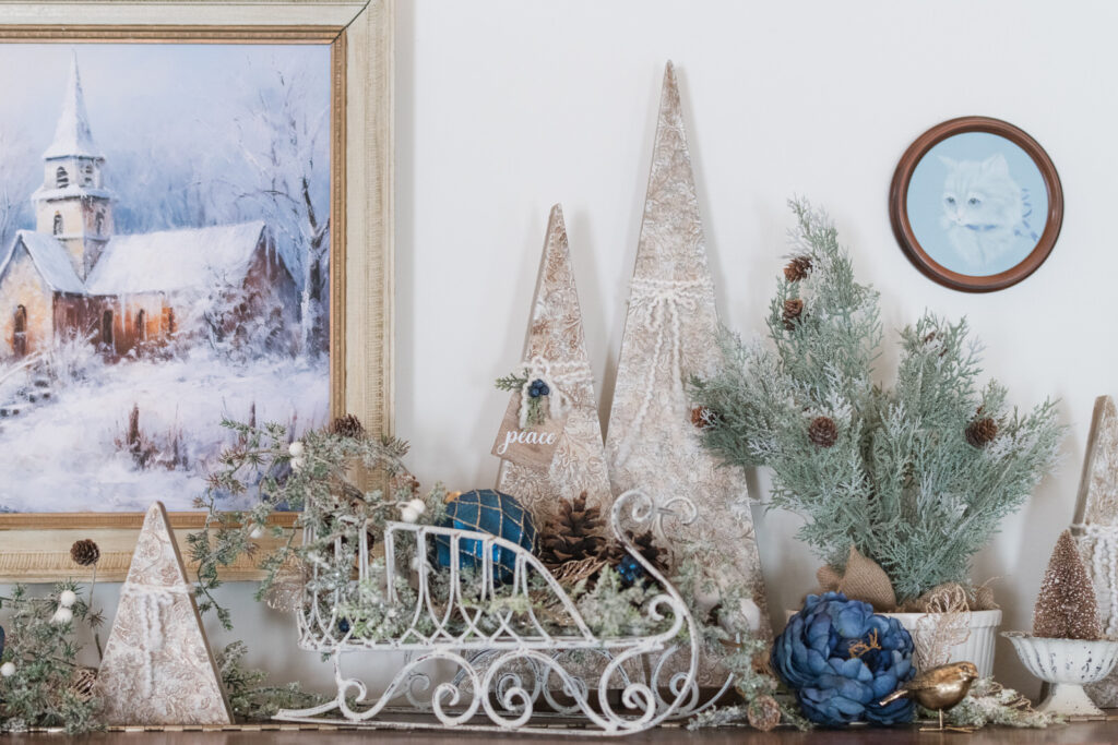 Christmas decorations on top of a piano with a gallery wall 