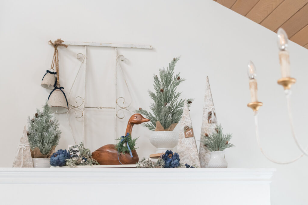 DIY textured Christmas trees and vintage wooden goose with blue ribbon above entryway closet.