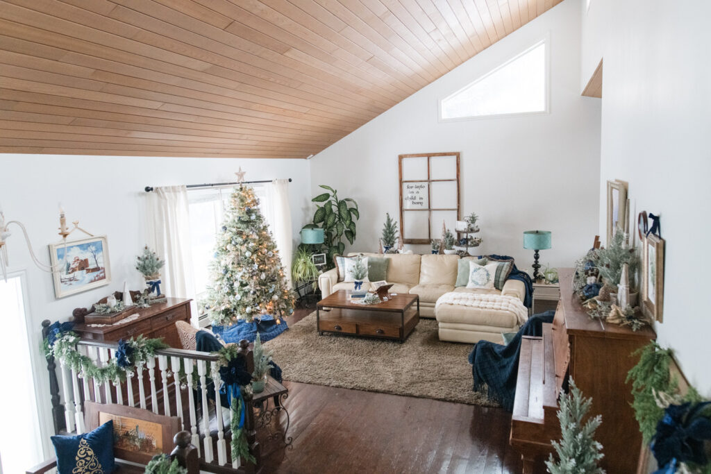Elegant farmhouse Christmas living room with blue, gold, and white Christmas tree