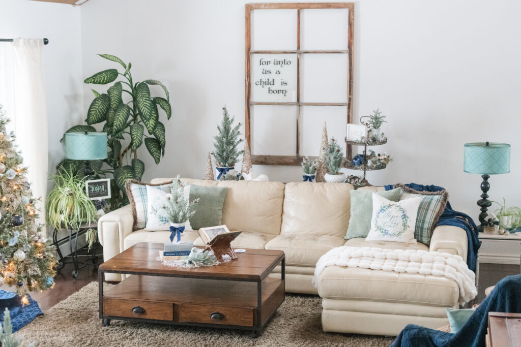 Cream sofa with blue plaid and green pillows and Hope Has Come scripture pillow