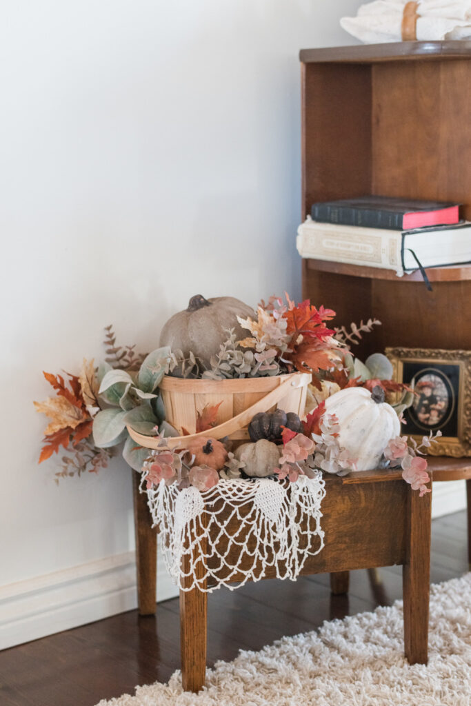Wood box filled with DIY textured pumpkins sitting beside a China cabinet in the dining room 