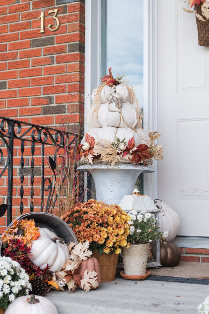 Topiary Pumpkins on front step with a Vintage apple basket spilling with faux pumpkins, pinecones, and orange florals for a cozy cottage fall look.