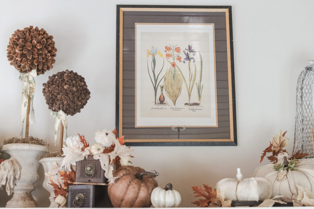 Pine Cone topiaries with Thrifted Art and vintage sewing machine drawers, layered with pumpkins and fall florals above kitchen cabinets 