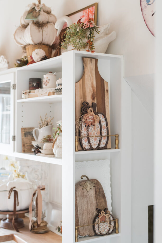 Fall decorated plate rail at the end of my baking nook with wood, cutting boards and pumpkins 