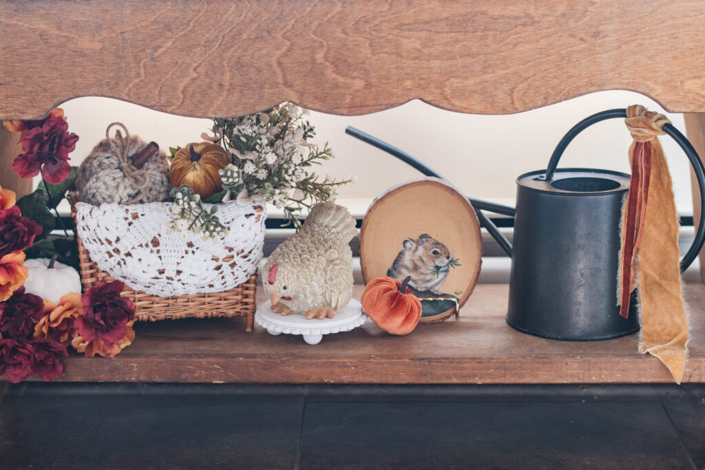 Bench in front of a kitchen window, where kitties eat decorated for fall 