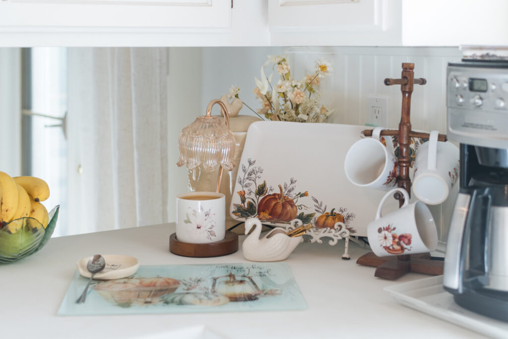 Farr coffee nook, decorated with a glass, cutting board, a tray, mugs, and a candle warmer 