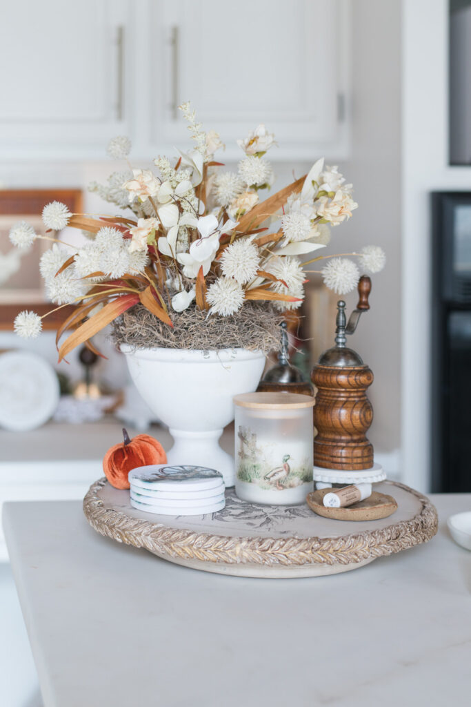 Lazy Susan decorated for fall with coasters, small, frosted canisters and vintage salt and pepper grinders