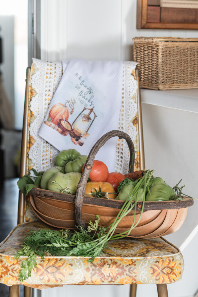 Vintage chair with lace doily, fall tea towel, and basket of garden vegetables