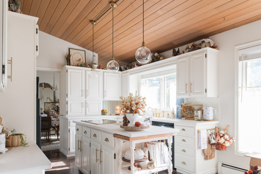 Full kitchen view with painted island, wood ceiling, and warm autumn details.