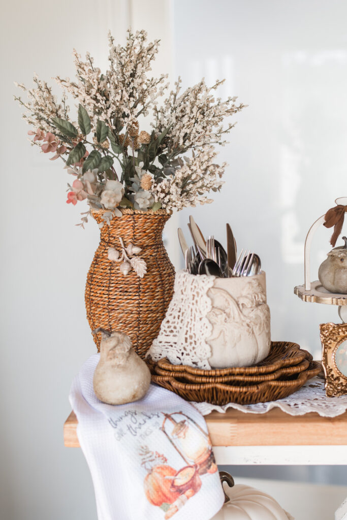Ceramic pot used as cutlery holder with clay pumpkin mould accent for Thanksgiving buffet
