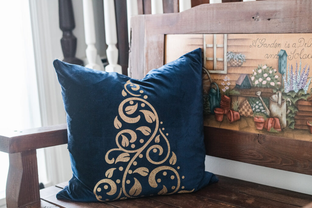 Front entry bench with a blue velvet pillow with gold glitter Christmas tree