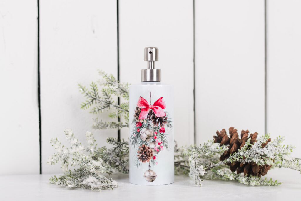 Christmas soap dispenser with pinecones, poinsettias, and festive red ribbon