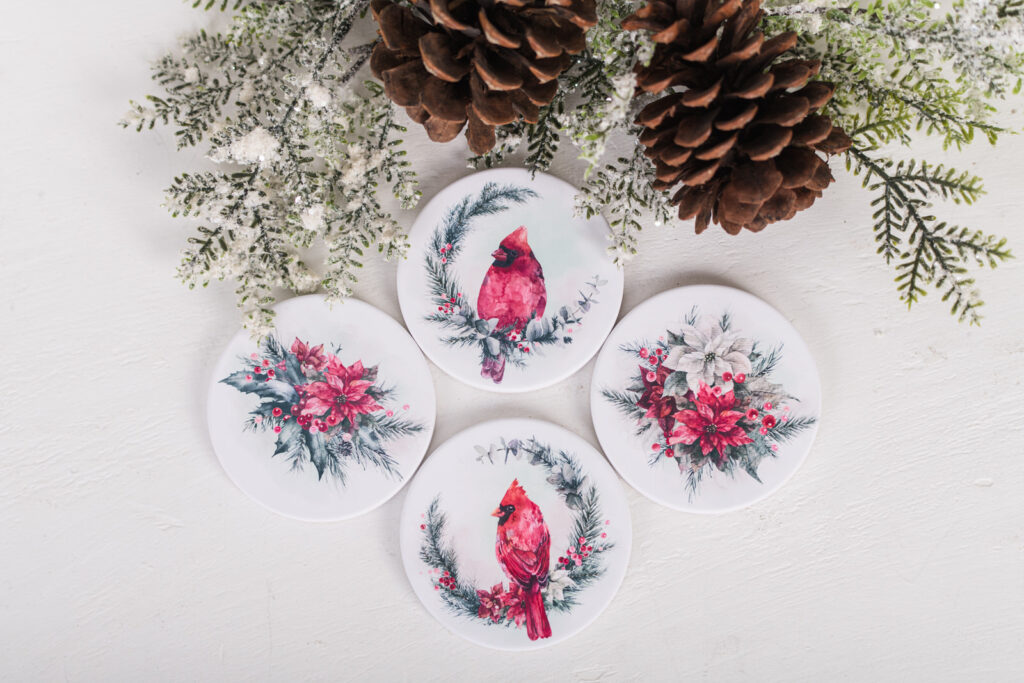 Ceramic Christmas coasters with red poinsettias and cardinal artwork