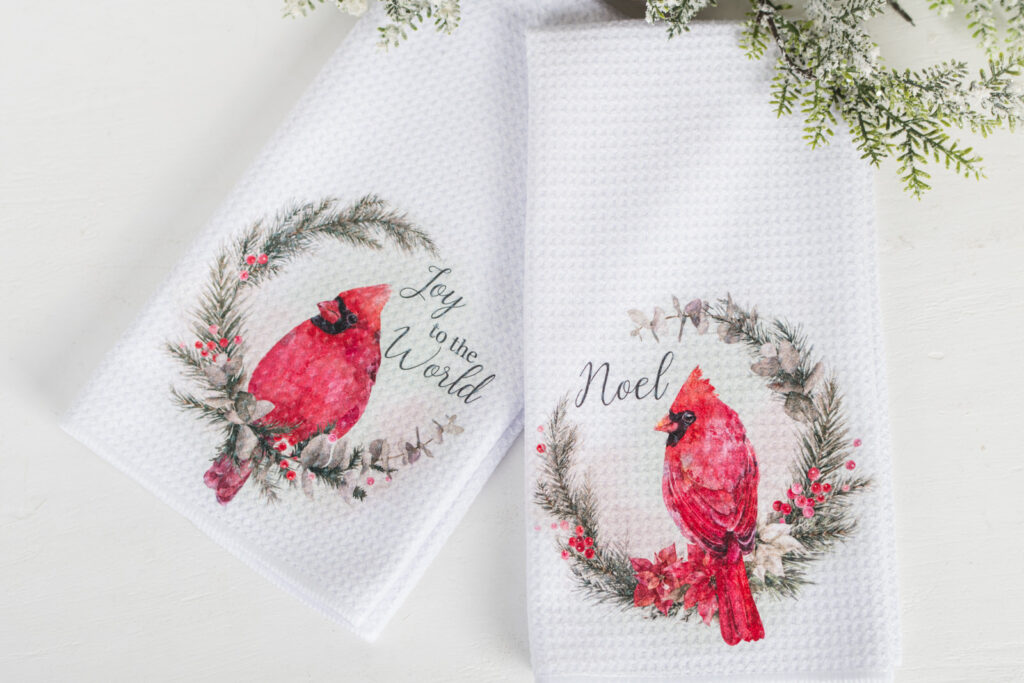 Classic Christmas tea towel with red poinsettias, cardinal, and scripture design