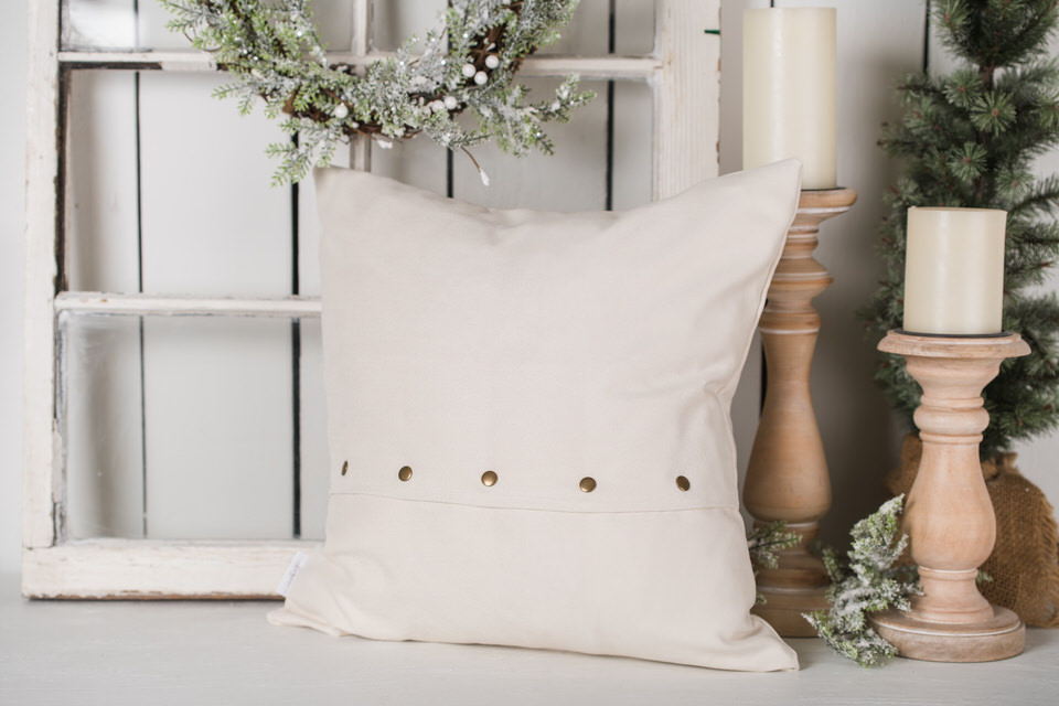 Back of an 18 x 18" oatmeal suede pillow with antique looking snap closure