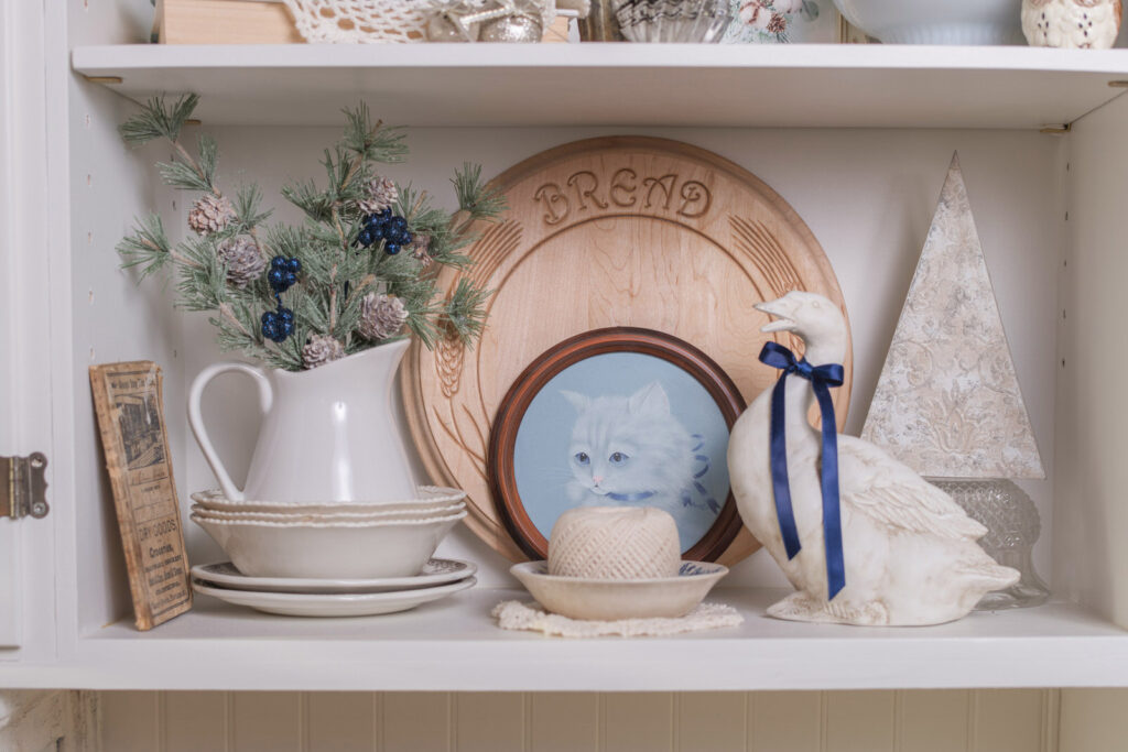Christmas decor styled on a shelf in the kitchen, a goose with a Christmas bow to make him feel festive
