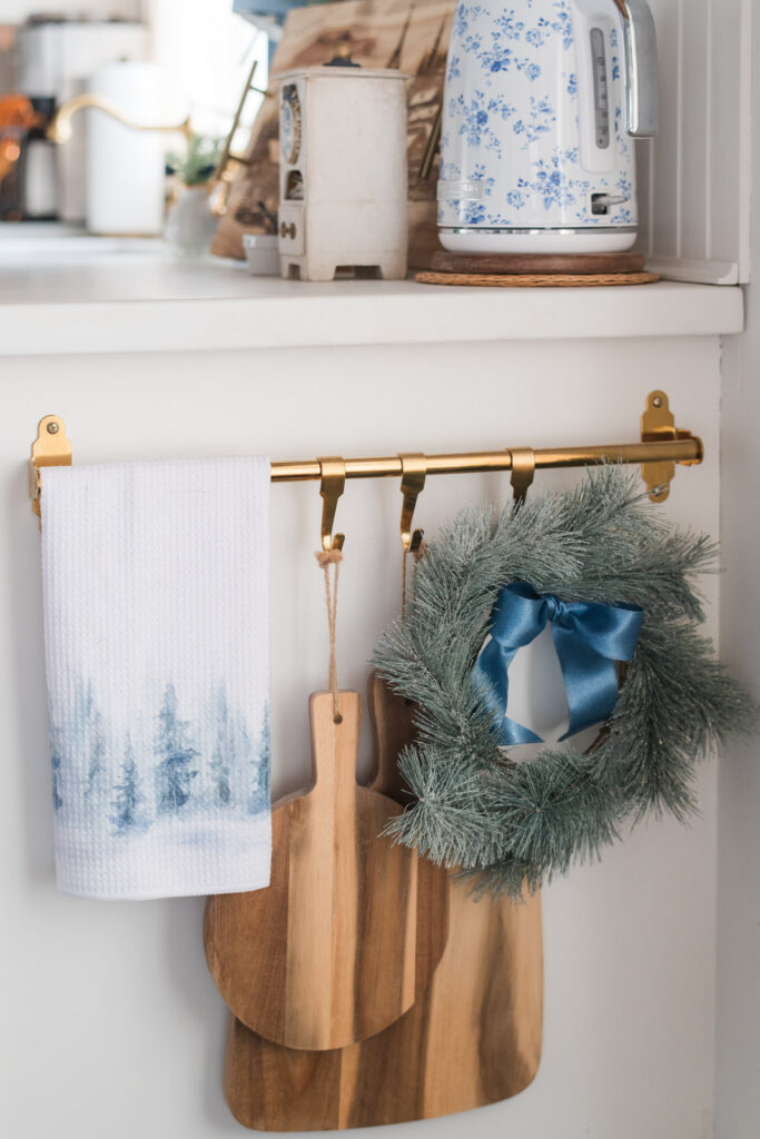 Christmas tea towels styled as decor in a cozy kitchen with blue and white accents