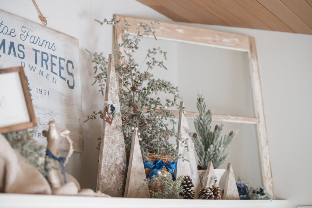 DIY textured Christmas trees mixed with faux Christmas trees above kitchen cabinets