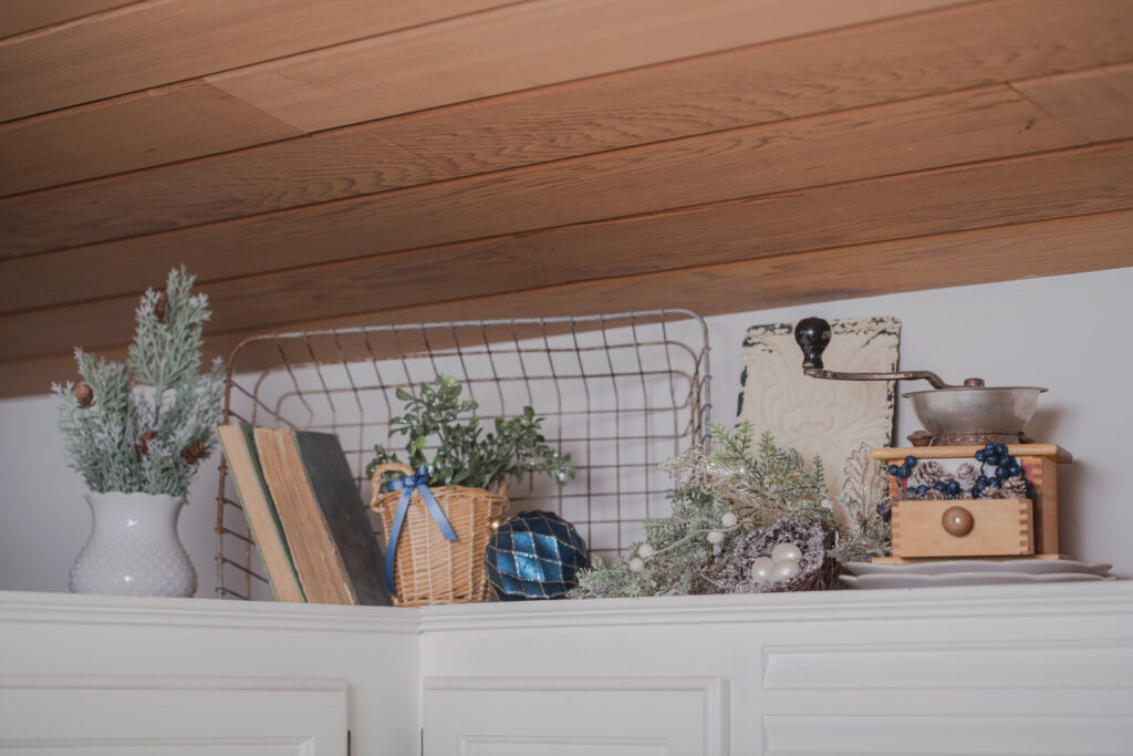 Above cabinet Christmas styling with faux trees, baskets, and collected holiday decor