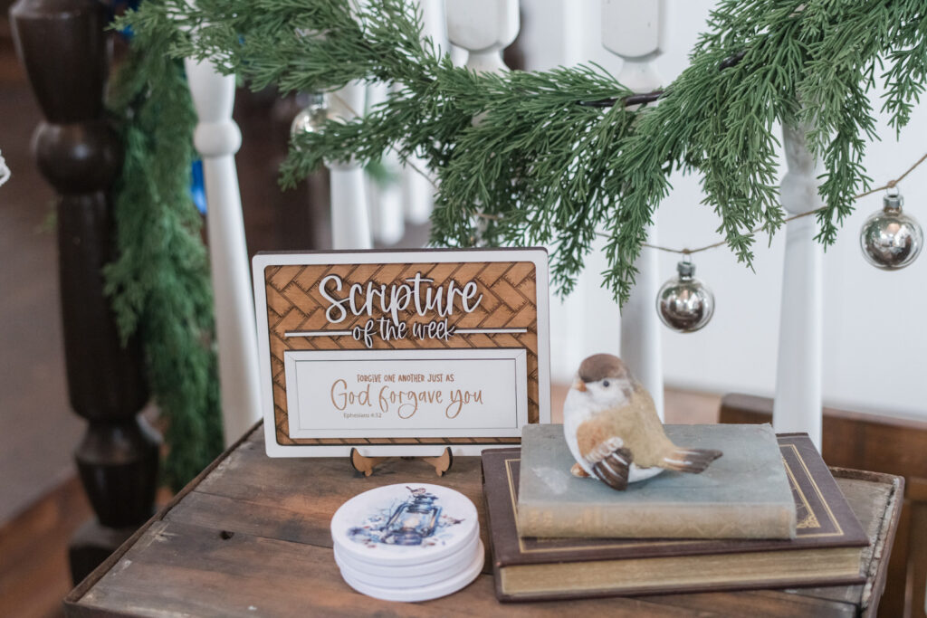 vintage table styled with a scripture of the week sign, vintage books and Let it snow coasters