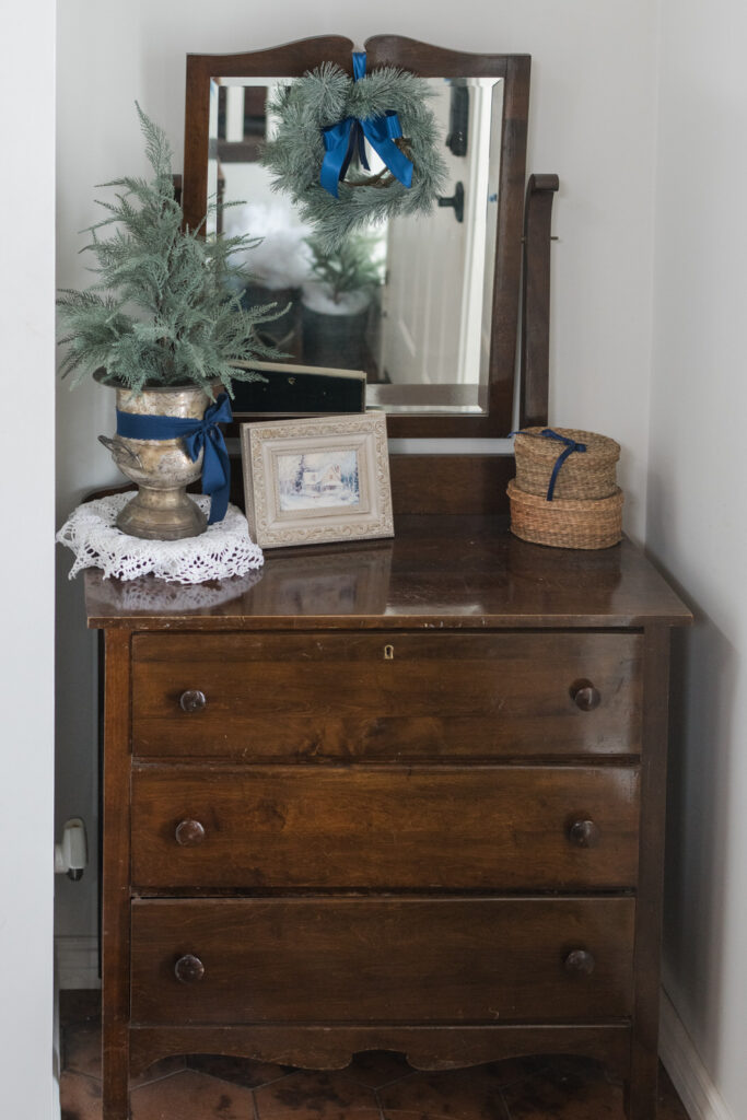 Vintage dresser used for storage in the front entrance styled for Christmas