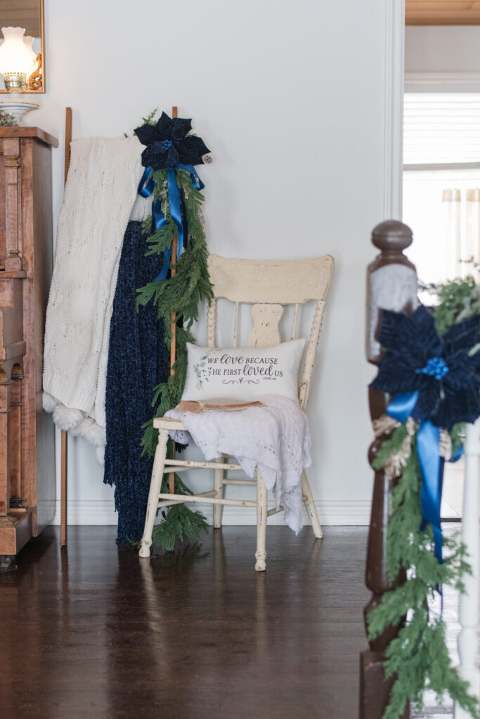Blanket ladder styled for Christmas, sitting beside a chair with a pillow and blanket